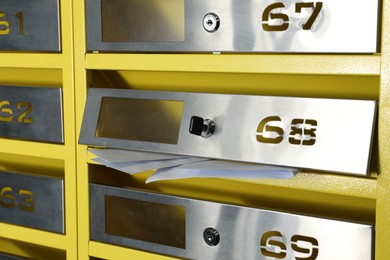 Metal mailboxes with keyholes, numbers and receipts indoors