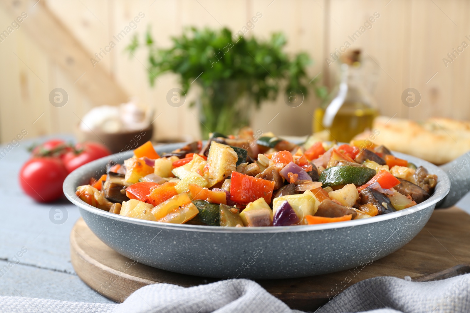 Photo of Delicious ratatouille in frying pan on grey table, closeup. Space for text