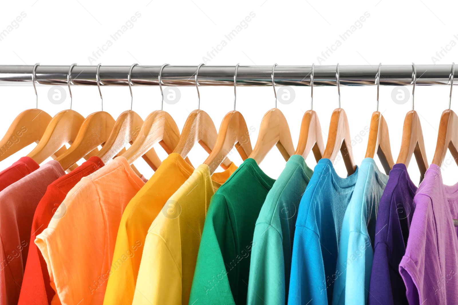 Photo of Rack with rainbow clothes on light background