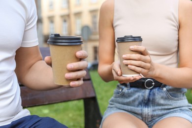 Photo of Coffee to go. Couple with paper cups outdoors, closeup
