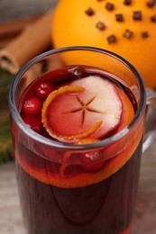 Photo of Aromatic mulled wine in glass cup on table, closeup