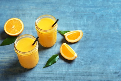 Jars of orange juice and fresh fruits on table