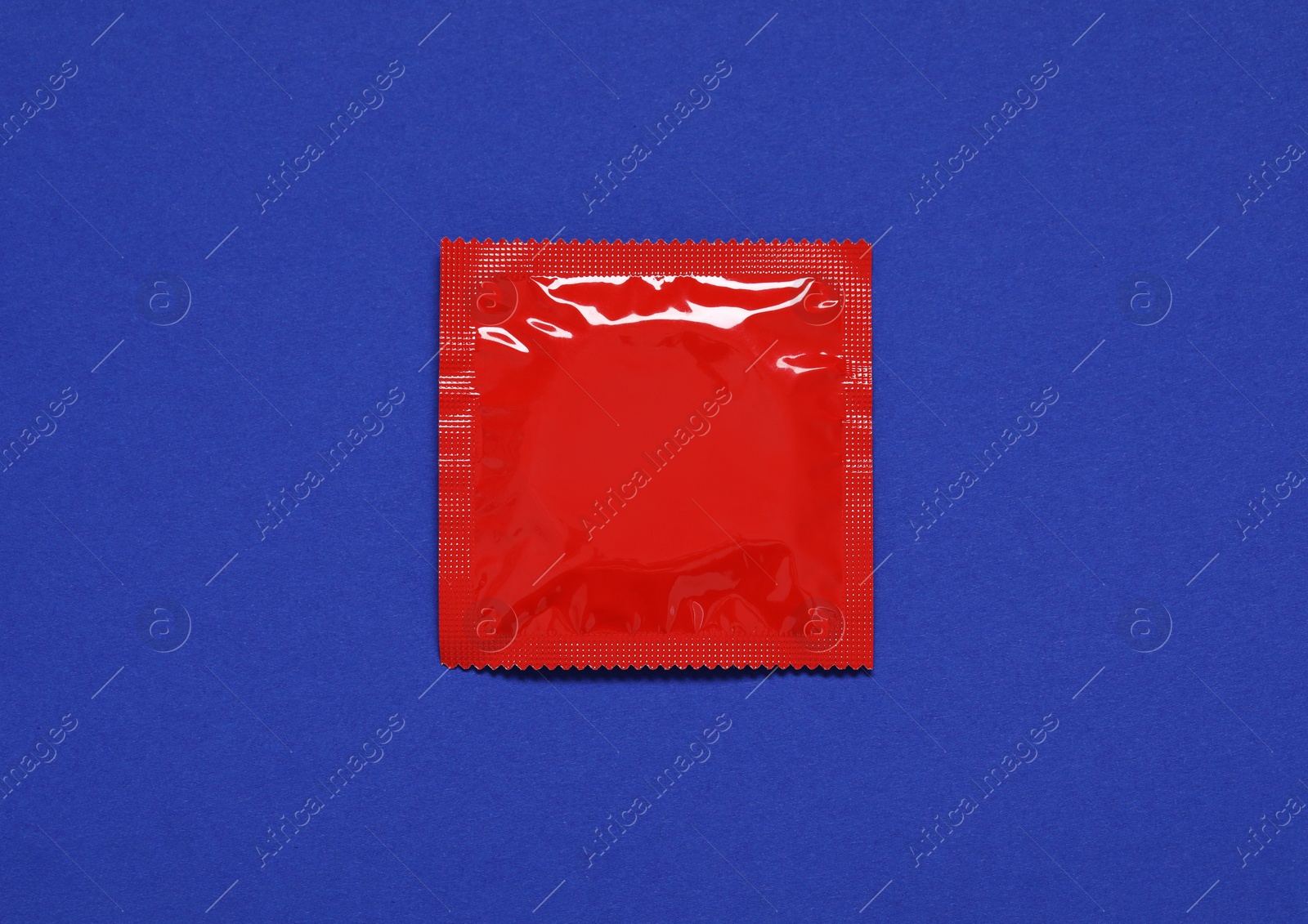 Photo of Condom package on blue background, top view. Safe sex