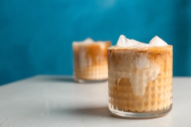 Glass with cold brew coffee and milk on table