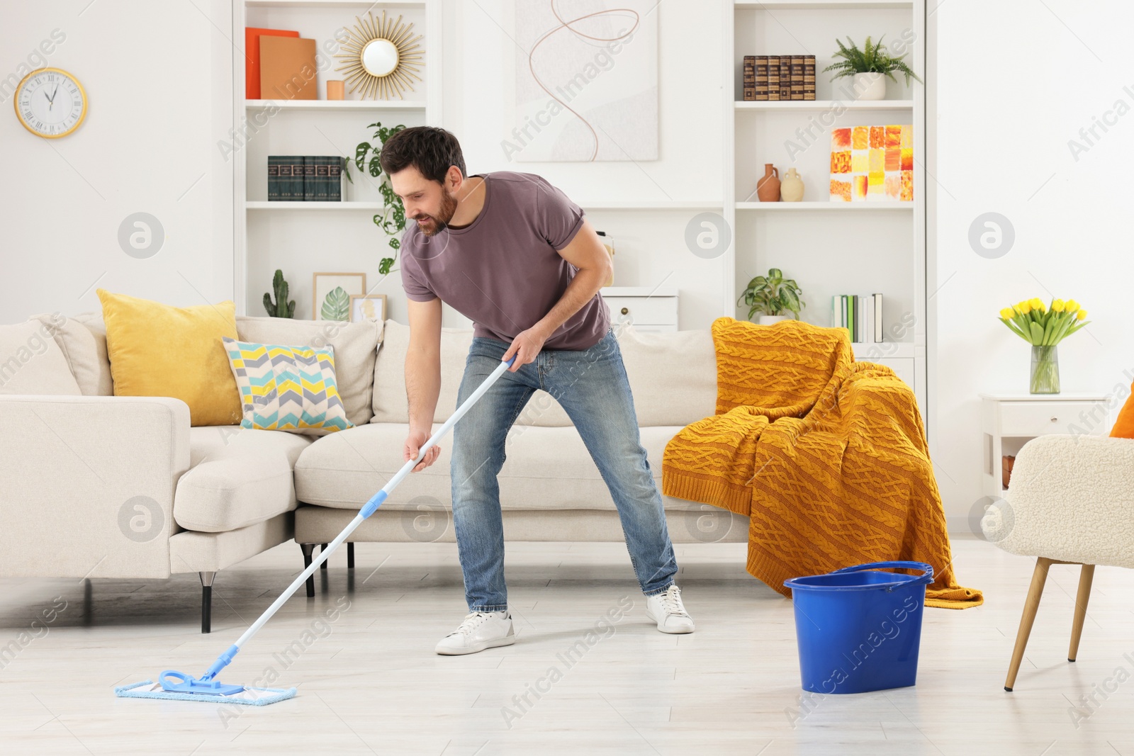 Photo of Spring cleaning. Man with mop washing floor at home