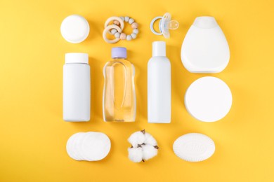 Photo of Flat lay composition with baby care products and accessories on orange background