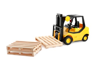 Photo of Toy forklift truck with wooden pallets on white background