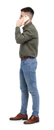 Man in shirt and jeans talking on phone on white background