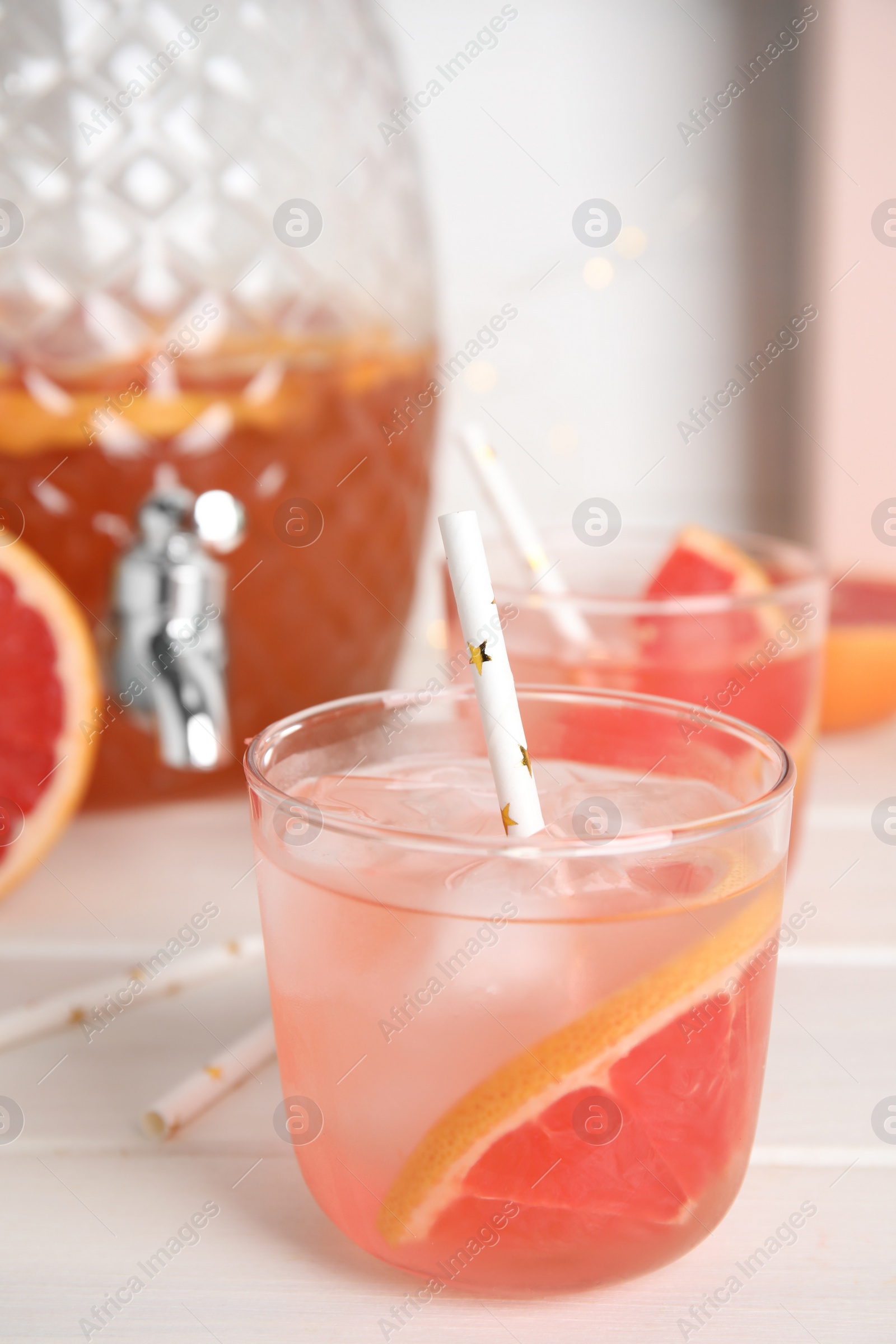 Photo of Delicious refreshing lemonade with grapefruit slices on white wooden table