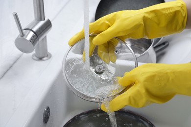 Woman washing dirty dishes in kitchen sink, closeup