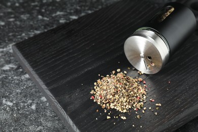 Photo of Overturned shaker with pepper on dark table. Space for text