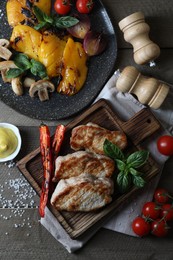 Delicious grilled meat and vegetables served on wooden table, flat lay