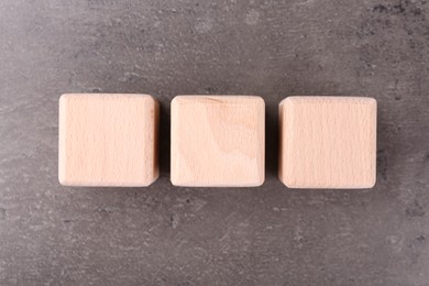 Photo of Wooden cubes with abbreviation ISO on grey textured table, flat lay