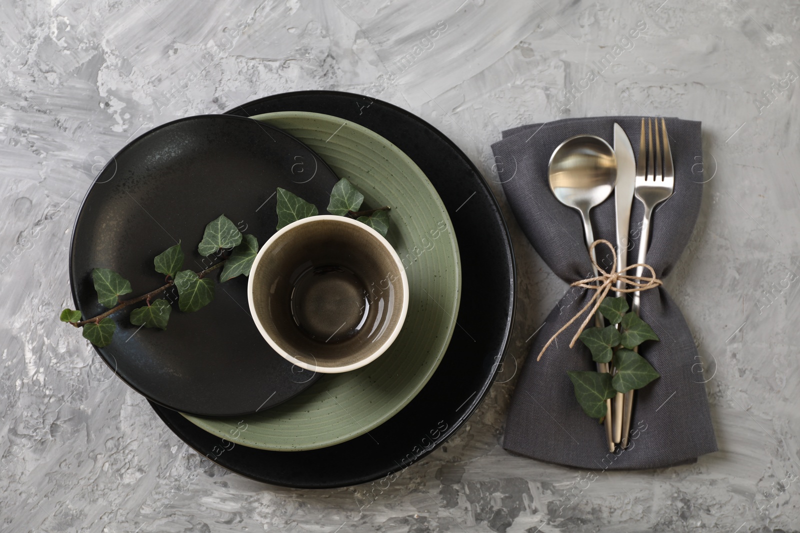 Photo of Stylish table setting. Dishes, cutlery, napkin and floral decor, top view