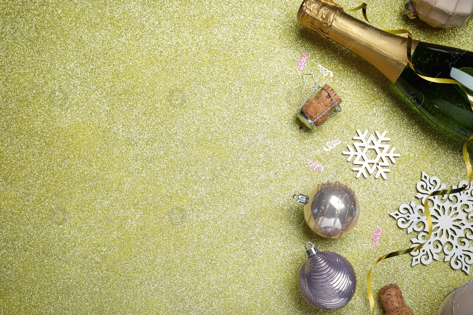 Photo of Flat lay composition with bottle of sparkling wine and festive decor on shiny background, space for text. Happy New Year