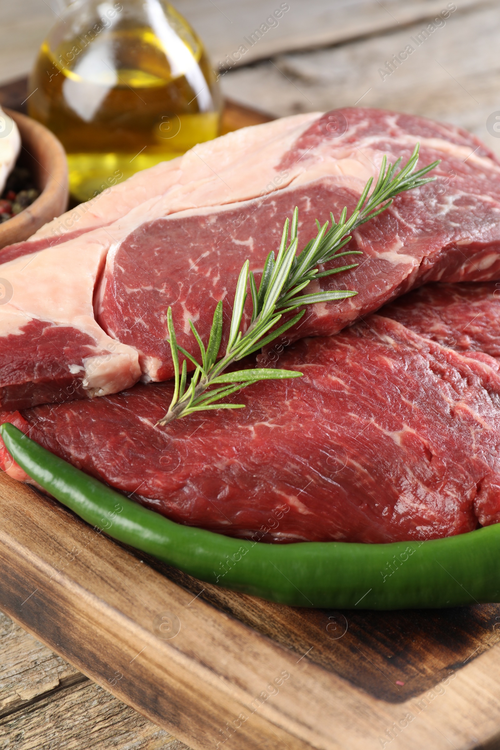 Photo of Fresh raw beef cut with spices on wooden table, closeup