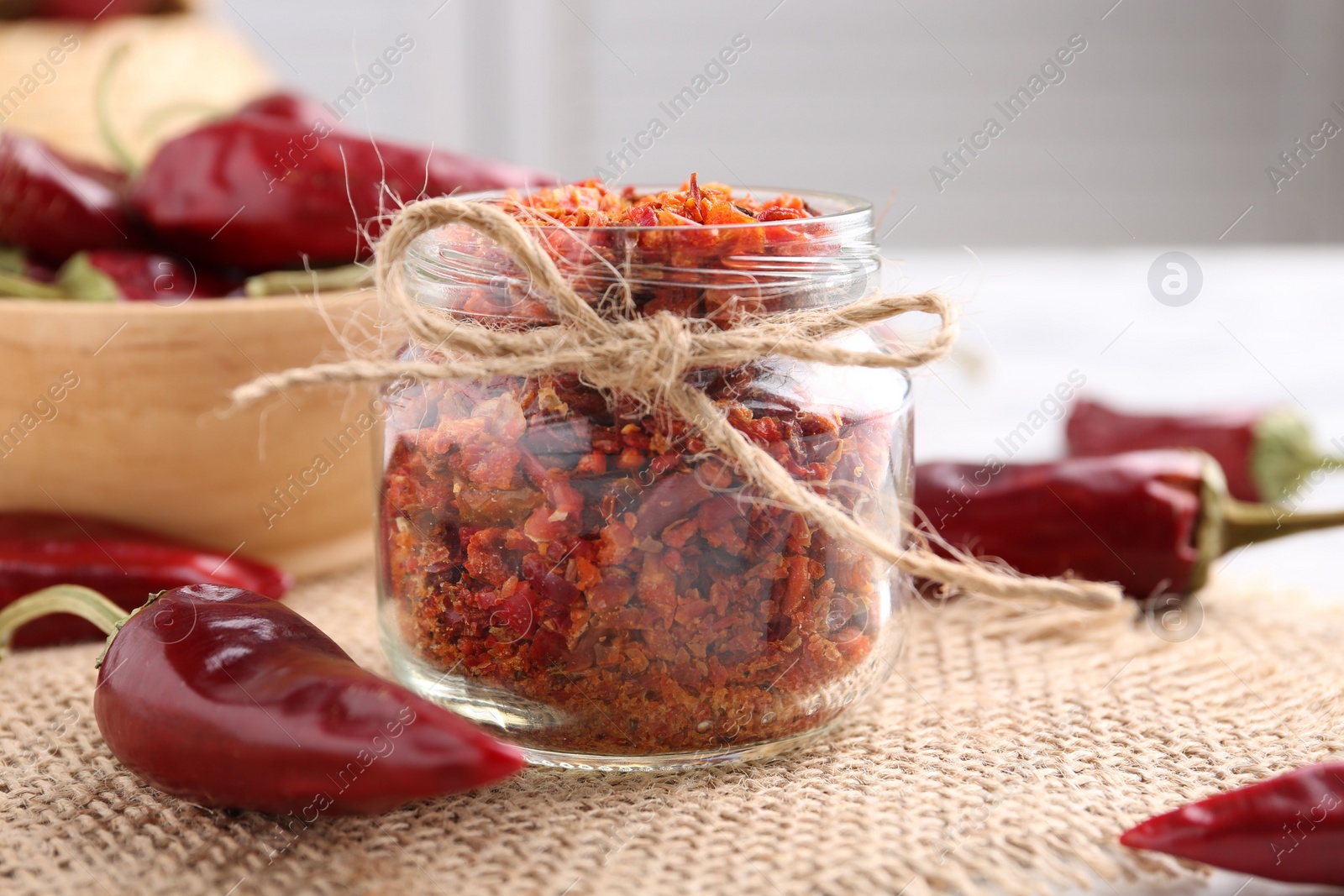 Photo of Chili pepper flakes and pods on table, closeup