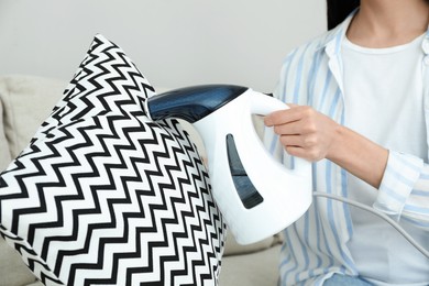 Woman steaming pillow at home, closeup view