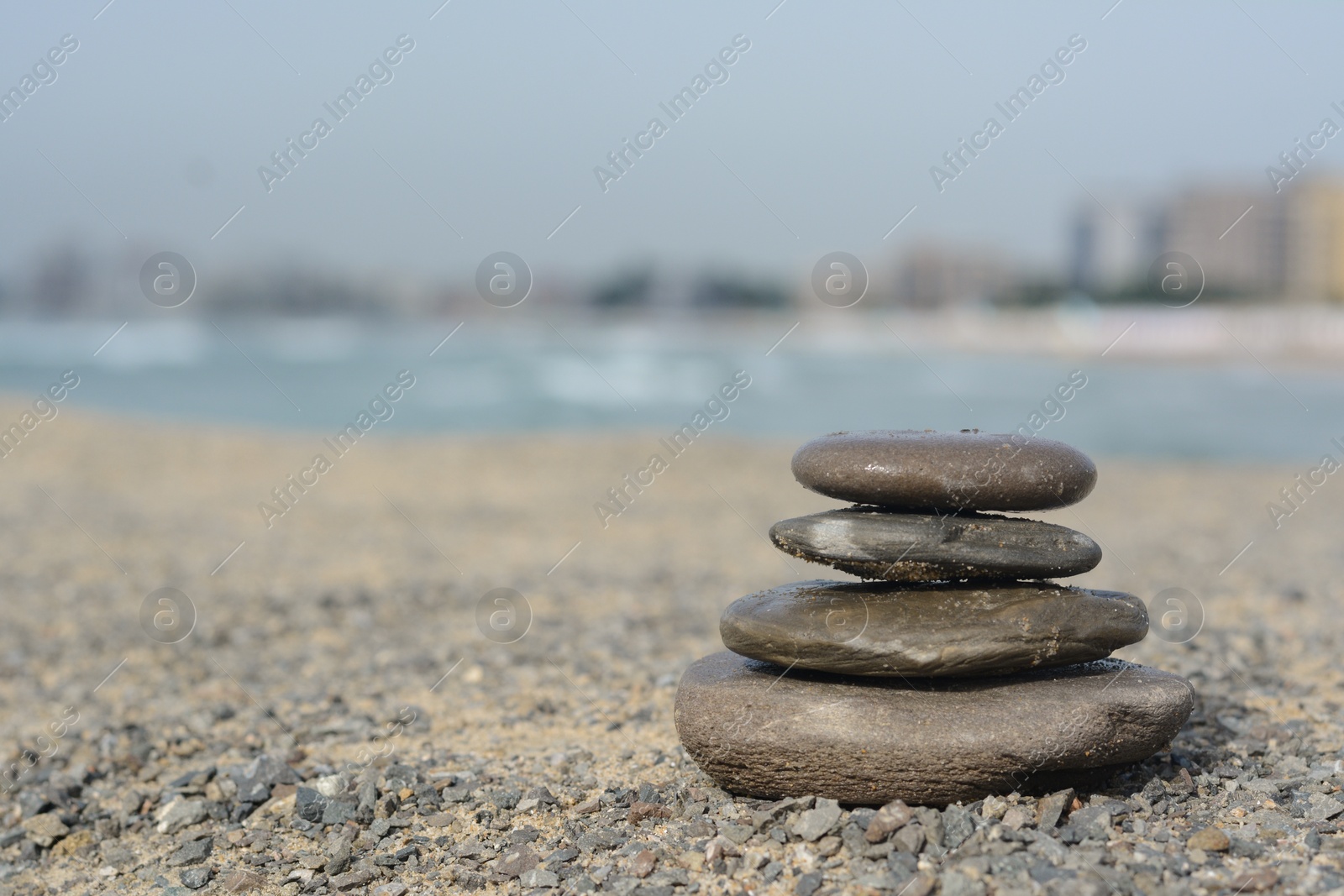 Photo of Stack of stones on sandy beach near sea, space for text