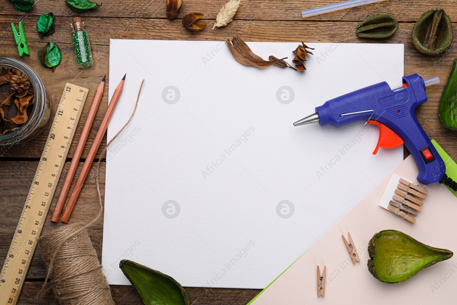 Photo of Hot glue gun and handicraft materials on wooden background, flat lay. Space for text