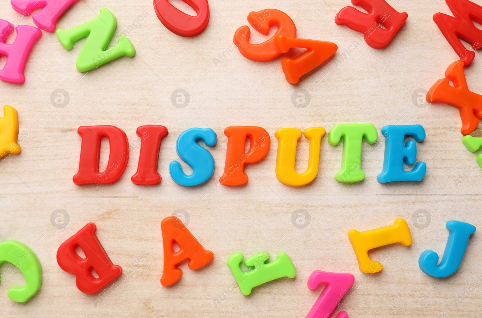 Photo of Word Dispute made of colorful letters on light wooden table, flat lay