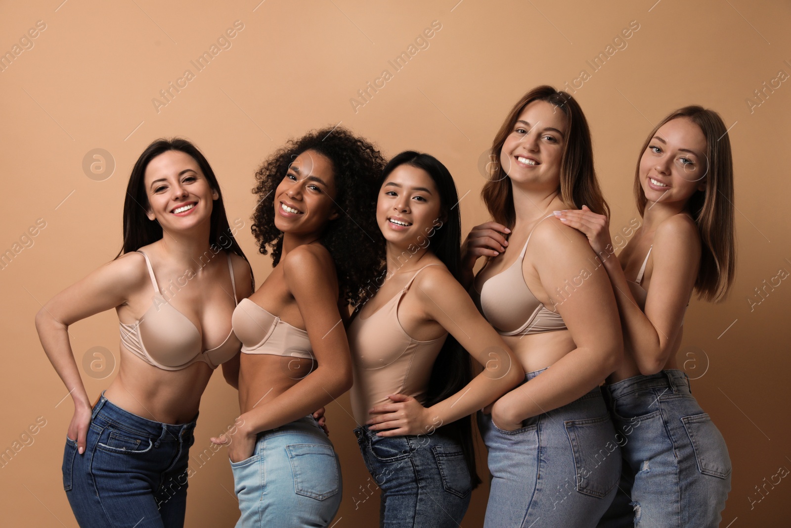 Photo of Group of women with different body types in jeans and underwear on beige background