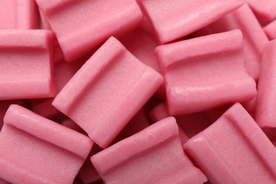 Photo of Tasty pink chewing gums as background, top view