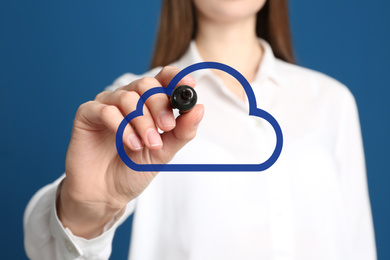 Image of Woman pointing at virtual cloud icon on blue background, closeup of hand. Data storage concept