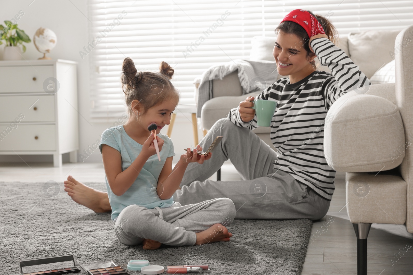 Photo of Young mother and her daughter spending time together at home