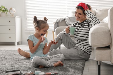 Young mother and her daughter spending time together at home