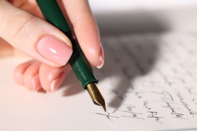 Photo of Woman writing letter with fountain pen, closeup