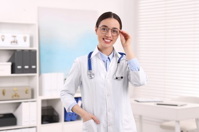 Photo of Medical consultant with glasses and stethoscope in clinic