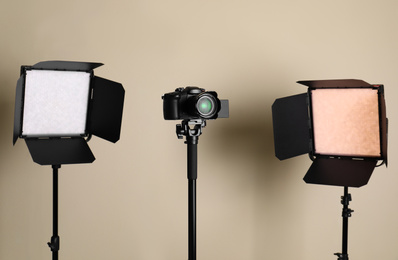 Photo of Professional video camera and lighting equipment on beige background