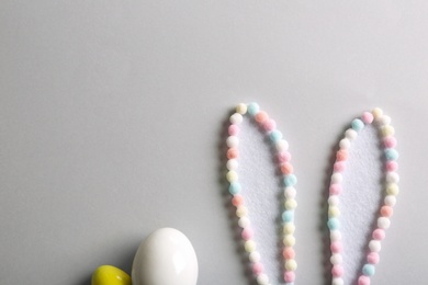 Photo of Flat lay composition of creative Easter bunny ears on light background, space for text