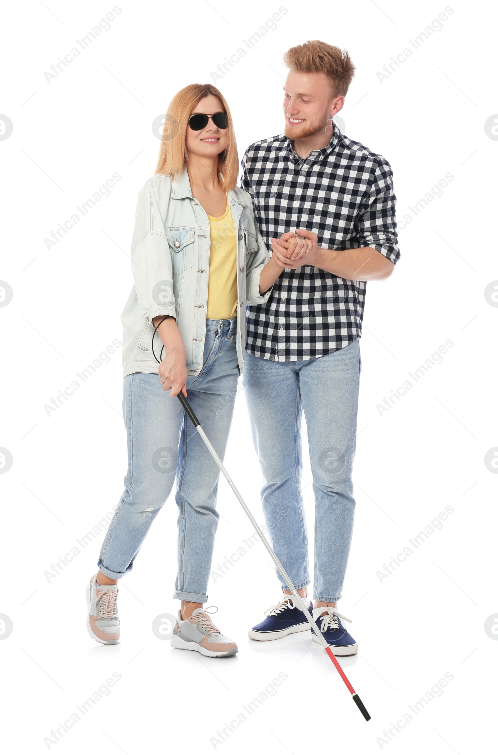 Photo of Young man helping blind person with long cane on white background