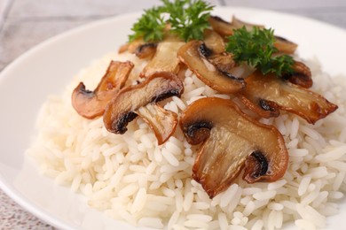 Photo of Delicious rice with parsley and mushrooms on plate, closeup