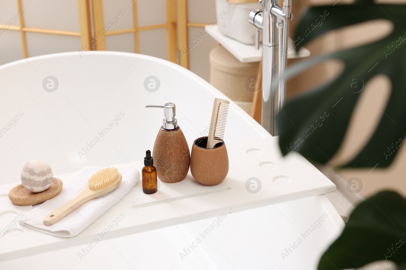 Photo of Different personal care products and accessories on bath tub in bathroom