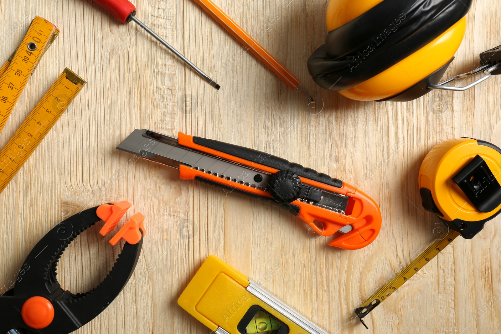 Photo of Flat lay composition with utility knife and different tools on wooden table