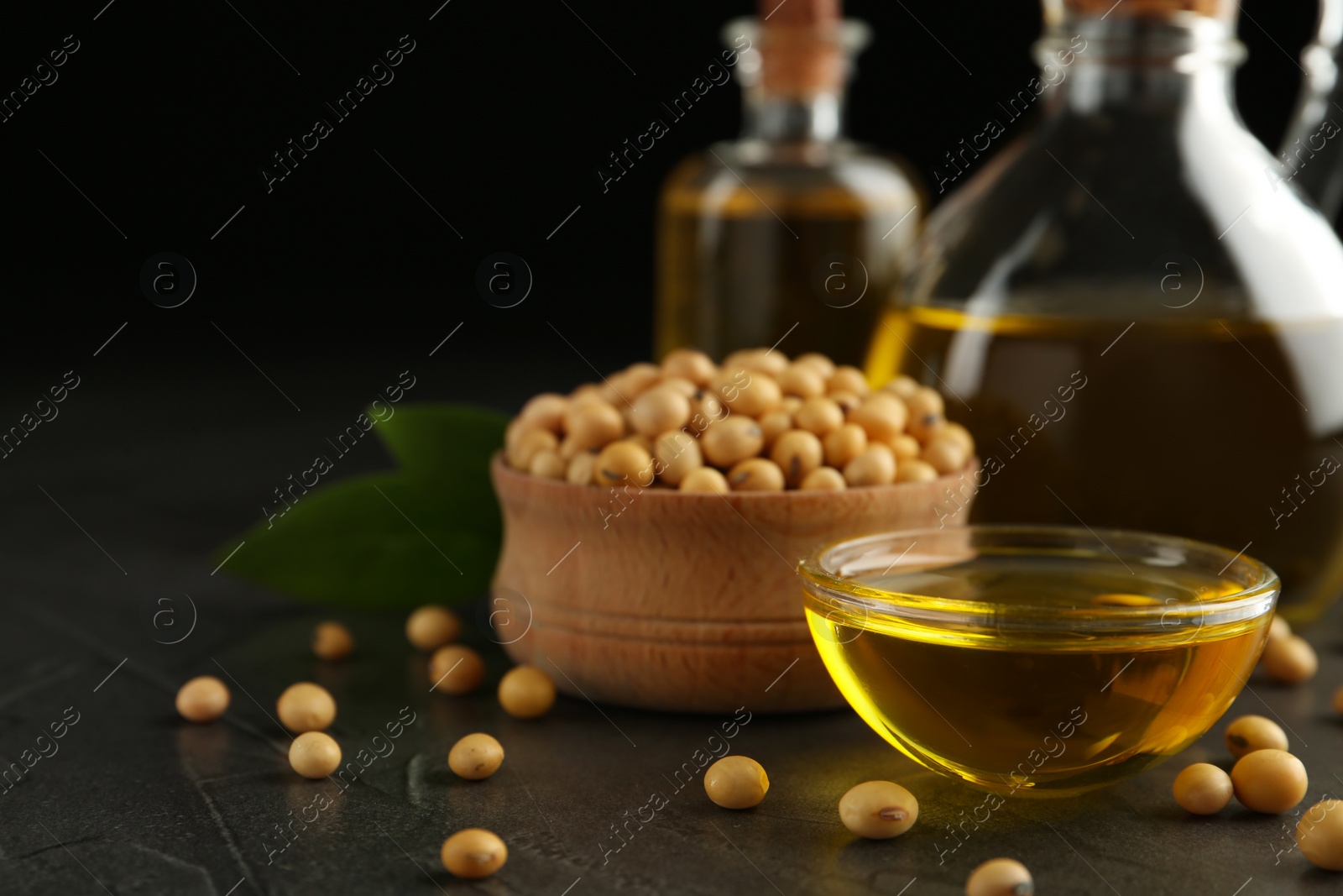 Photo of Composition with soybean oil on grey table, closeup. Space for text