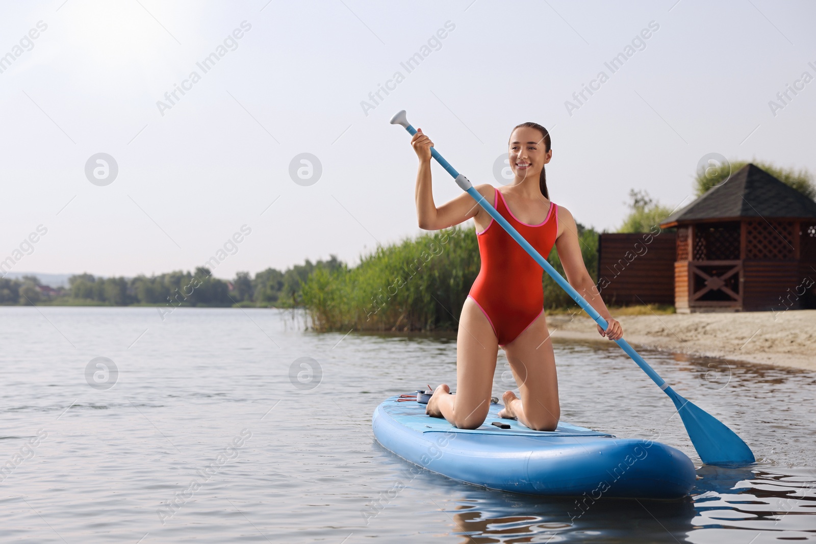 Photo of Woman paddle boarding on SUP board in sea, space for text