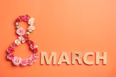 Photo of Phrase "8 March" made of beautiful flowers and wooden letters on color background, top view. Happy Women's Day