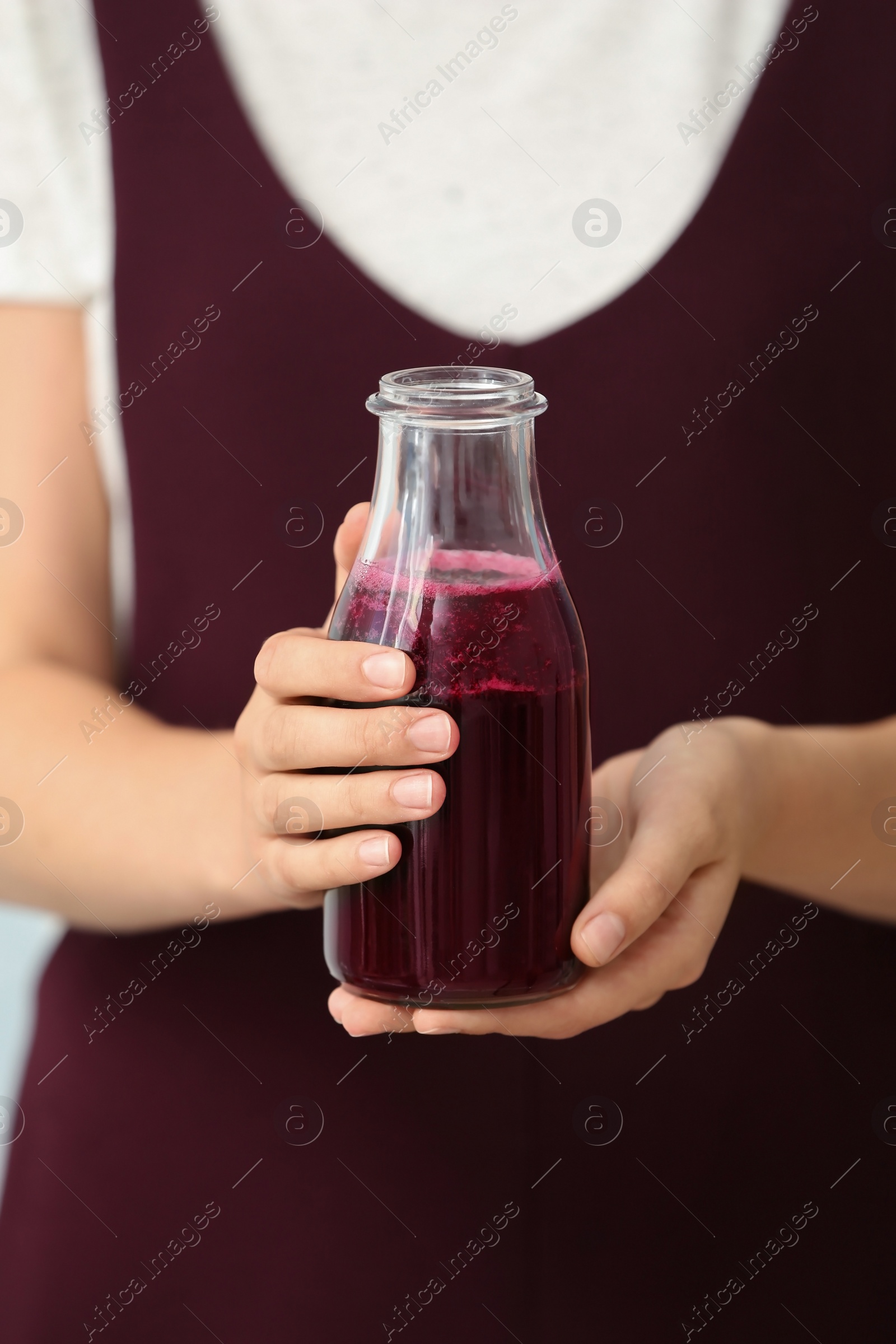 Photo of Woman with bottle of beet smoothie, closeup