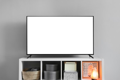 Image of Modern TV on cabinet near light wall indoors. Interior design