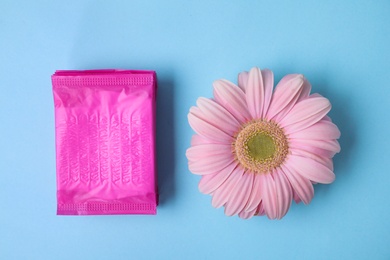 Photo of Flat lay composition with menstrual pads and gerbera flower on color background. Gynecological care