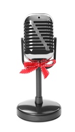 Photo of Retro microphone with red bow isolated on white. Christmas music