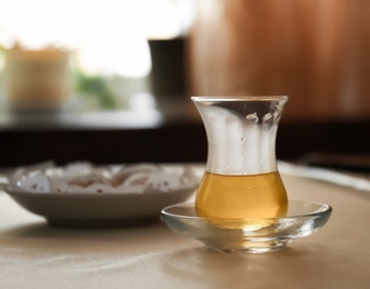 Glass cup of aromatic tea on table