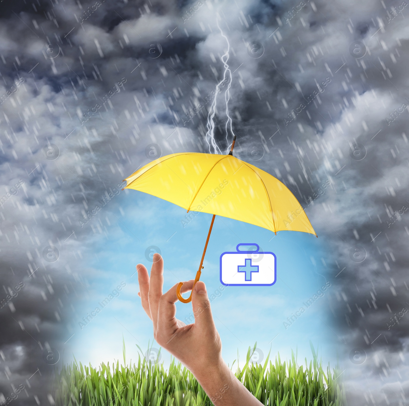 Image of Insurance concept. Man covering medical kit illustration with yellow umbrella during storm, closeup