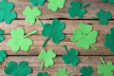 Photo of St. Patrick's day. Decorative clover leaves on wooden background, flat lay