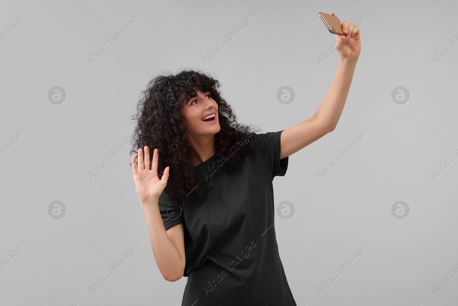 Photo of Beautiful young woman taking selfie on light grey background