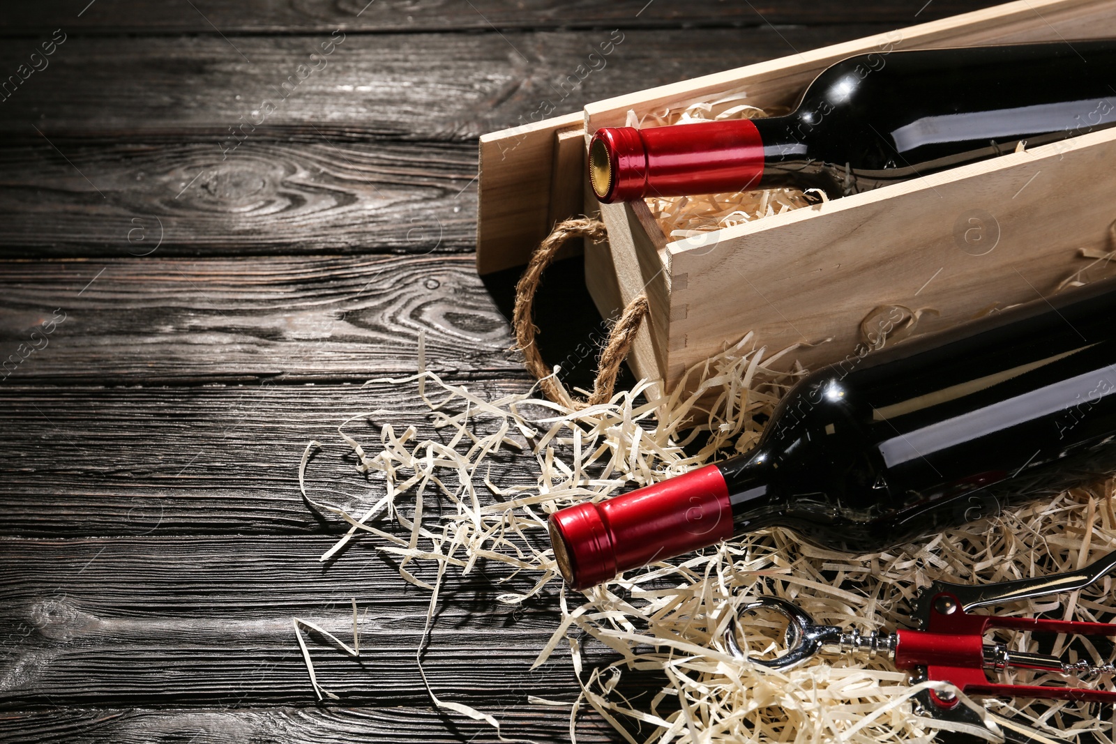 Photo of Crate and bottles of wine on wooden table. Space for text